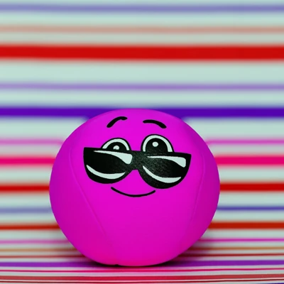 Magenta smiling ball with sunglasses against soft violet, red and mint stripes